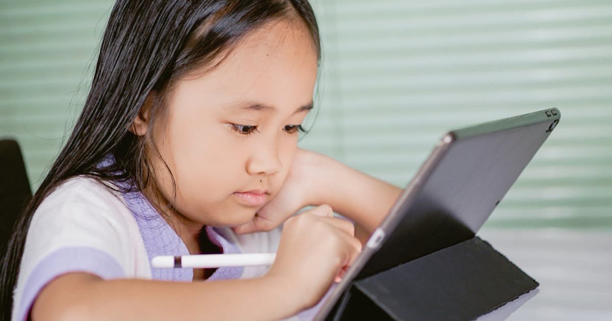 A young girl using a tablet for interactive English learning